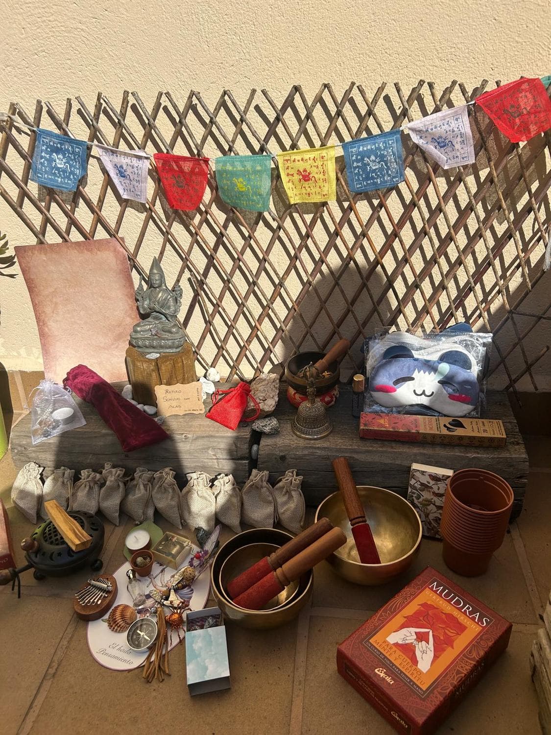 Altar del retiro con cuencos tibetanos, banderas de oración y detalles de bienvenida