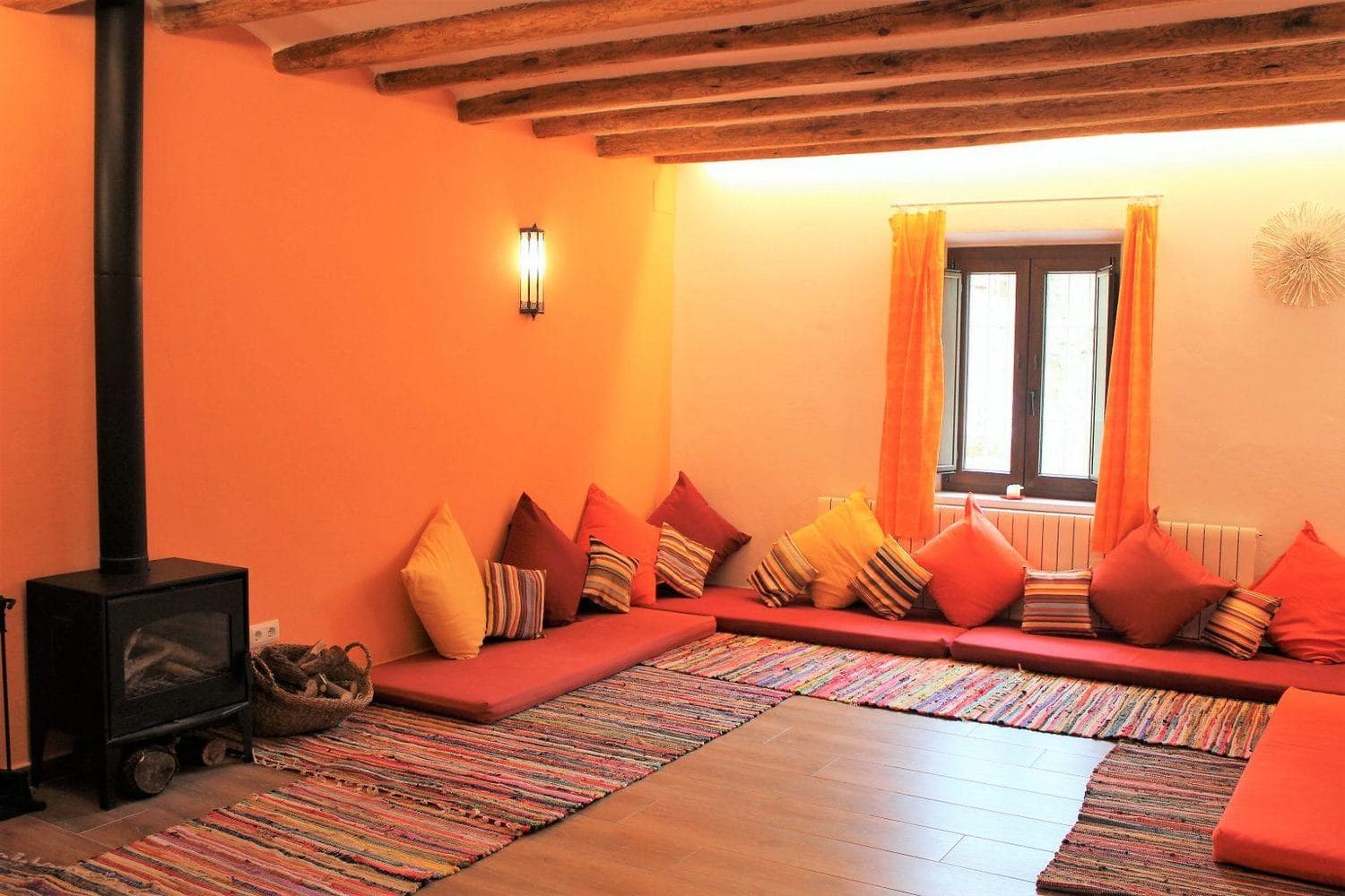 Sala de prácticas de la masía, con cojines en el suelo y chimenea